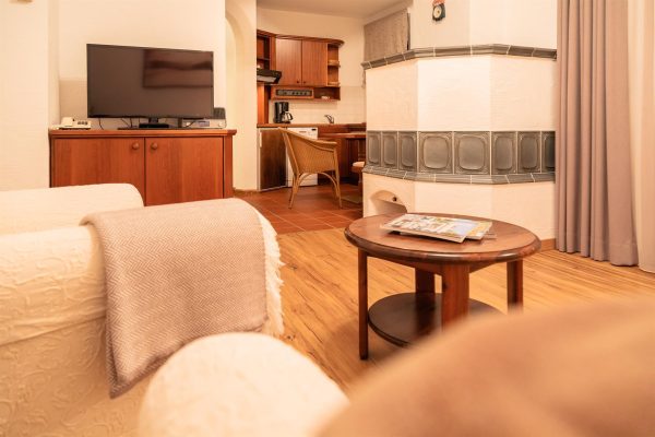 landhaus-apartments-appartement-11-wohnzimmer-kachelofen-tv Wohnzimmer im Apartment #11 mit TV