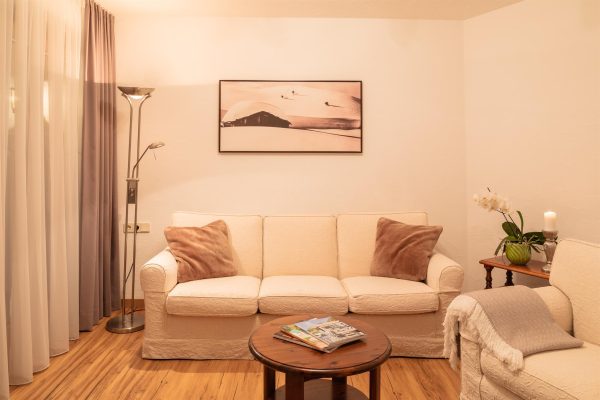 landhaus-apartments-appartement-11-wohnzimmer-sofa-gmuetlich Wohnzimmer im Apartment #11 mit Sofa und gemütlicher Sitzecke
