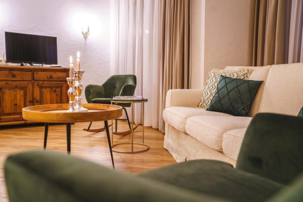 landhaus-apartments-appartement-12-wohnzimmer-sofa-tv-sideboard Wohnzimmer im Apartment #12 mit Sofa, TV und Sideboard