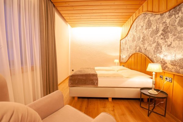 landhaus-apartments-appartement-15-schlafzimmer-doppelbett-waldtapete Schlafzimmer im Apartment #15 mit Doppelbett und Waldtapete