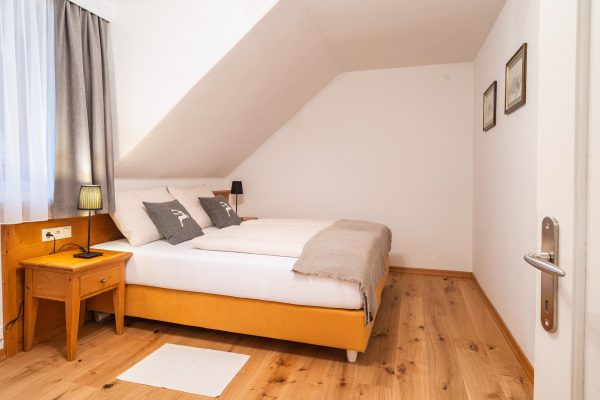 landhaus-apartments-appartement-18-schlafzimmer-doppelbett-hirschkissen Schlafzimmer im Apartment #18 mit Doppelbett und Hirsch-Dekokissen