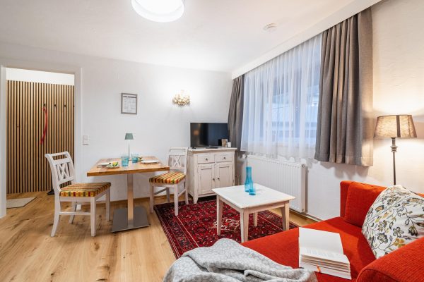 landhaus-apartments-appartement-18-wohnzimmer-sofa-esstisch-tv Wohnzimmer im Apartment #18 mit Sofa, Esstisch und TV